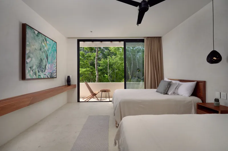 Casa David bedroom with two beds, a large painting and a sliding door open to a terrace with a chair