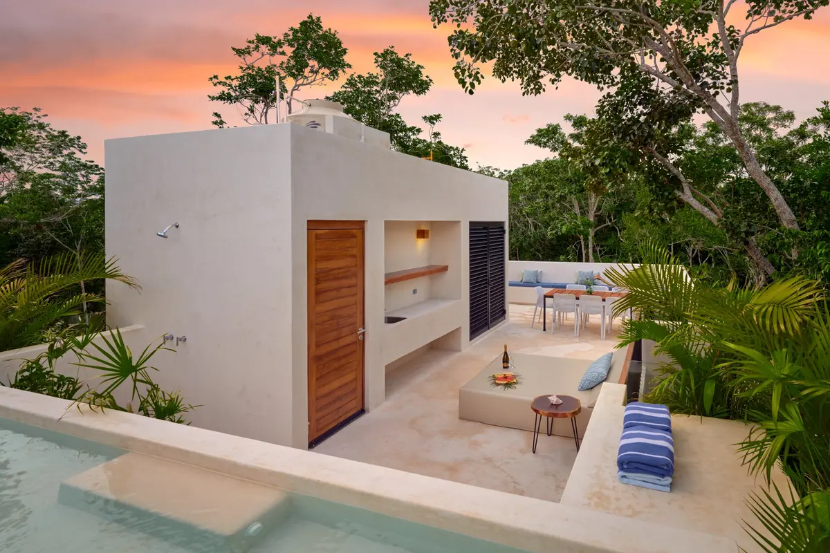Casa David rooftop pool at sunset with lounge seating and a dining table behind
