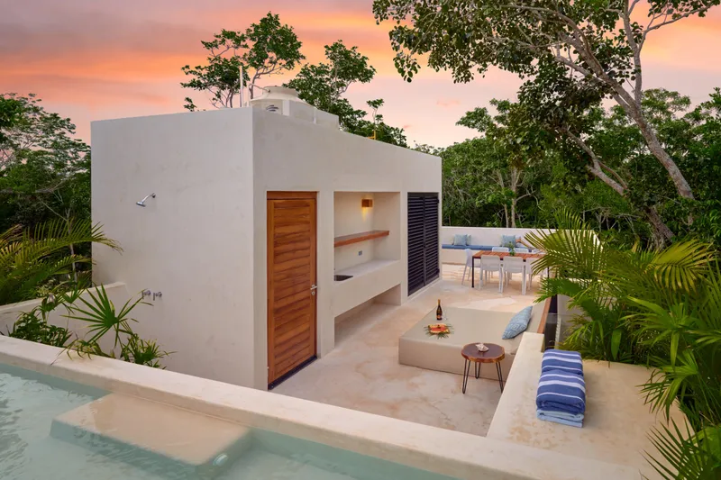 Casa David rooftop pool at sunset with lounge seating and a dining table behind