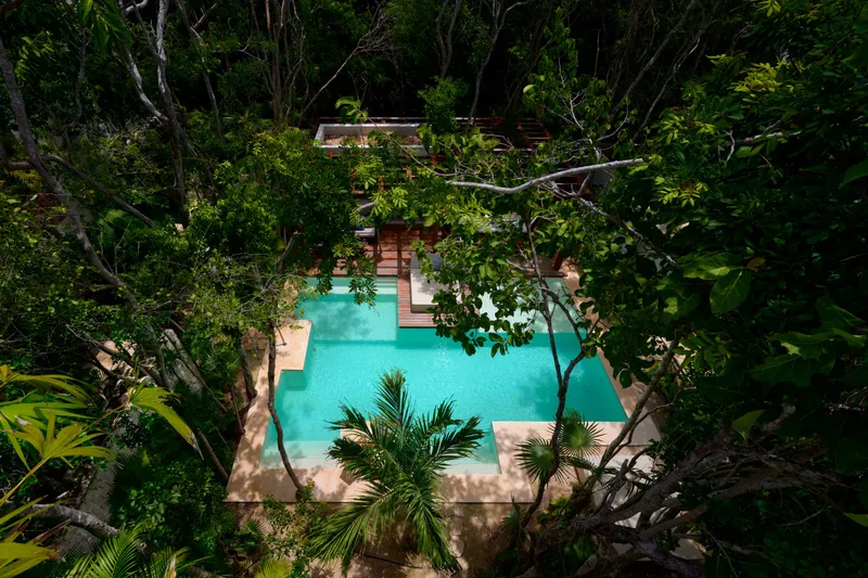 Casa Emilia pool and stone deck seen from above through the tree canopy