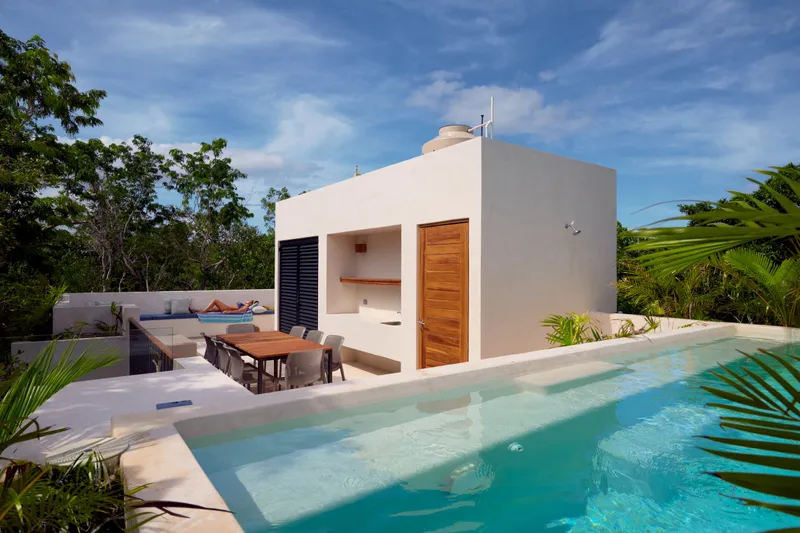 Casa Lucas rooftop pool by day with a wooden dining table and a lounge bench