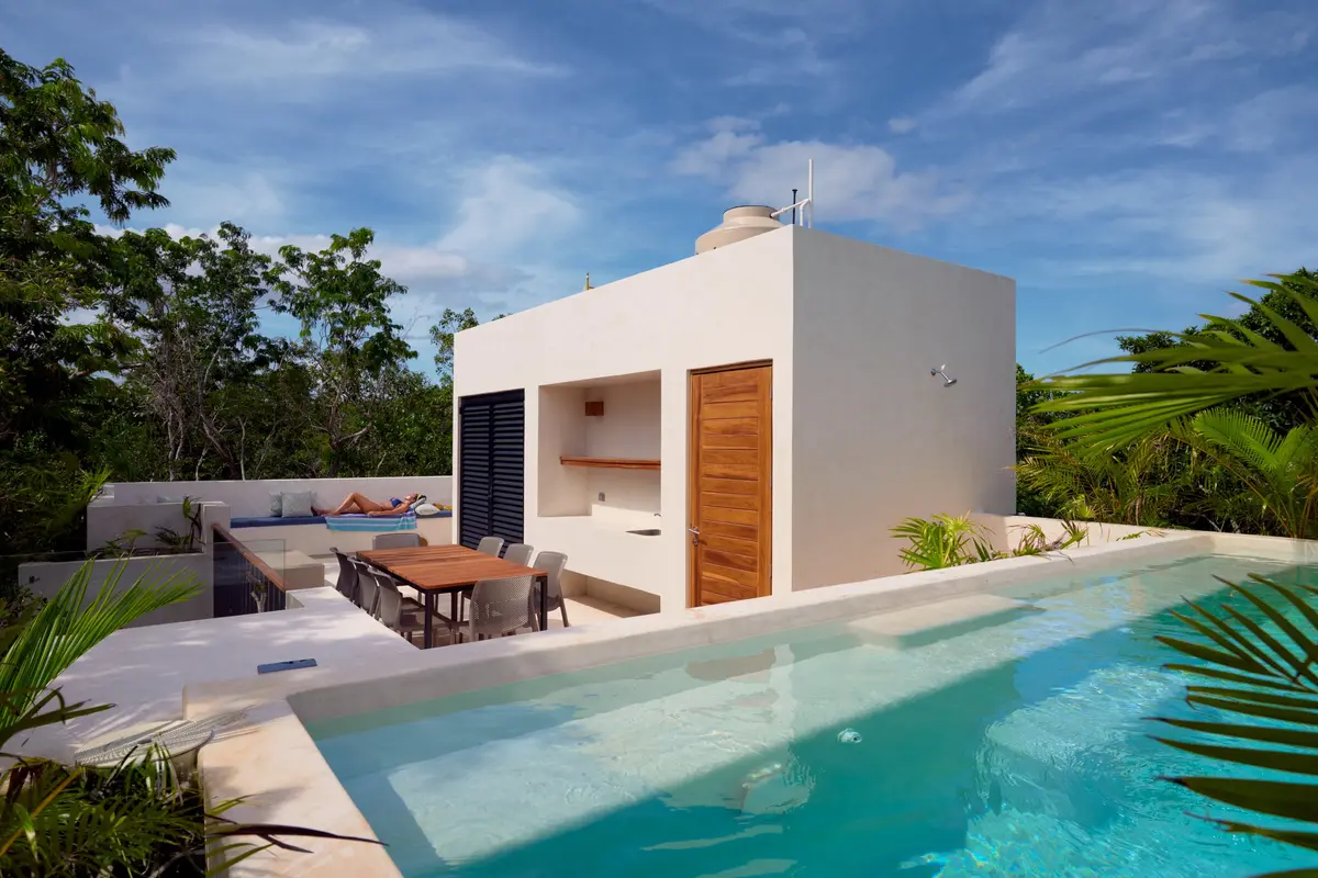 Casa Lucas rooftop pool by day with a wooden dining table and a lounge bench