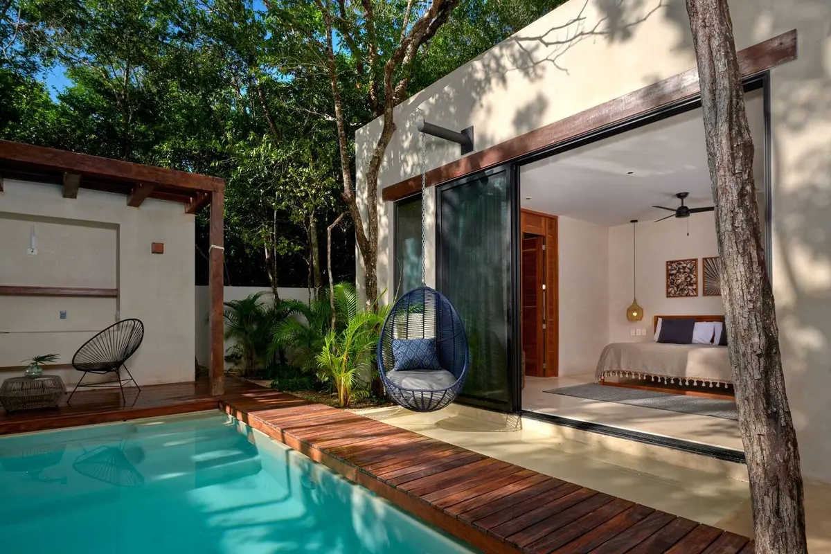 Casa Lydia master bedroom with sliding glass doors open to the pool deck and a hanging chair