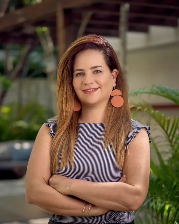Michelle Prier, owner and host of Aldea Kaan Tulum, standing in a garden with her arms crossed
